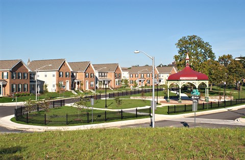 a park with a gazebo and houses in the background