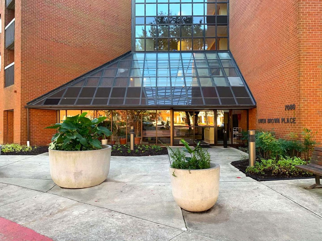 an entrance to a building with plants in front of it