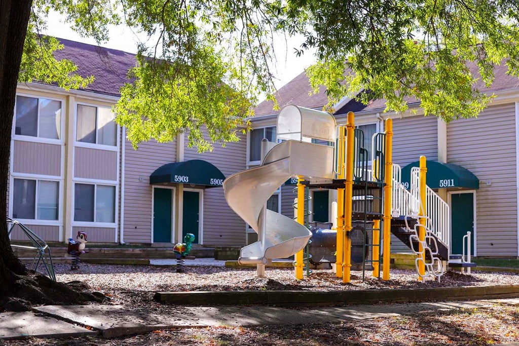 a playground in front of a building with a slide