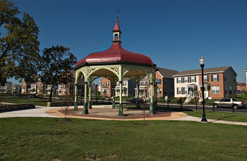 a gazebo in a park with a building in the background