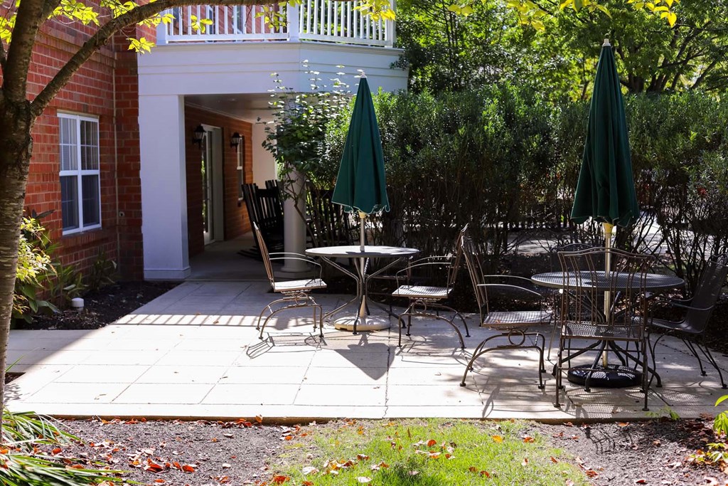 a patio with tables and chairs and umbrellas