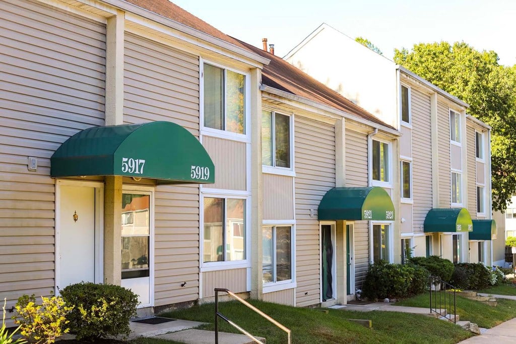 a row of houses with green awnings and a sidewalk