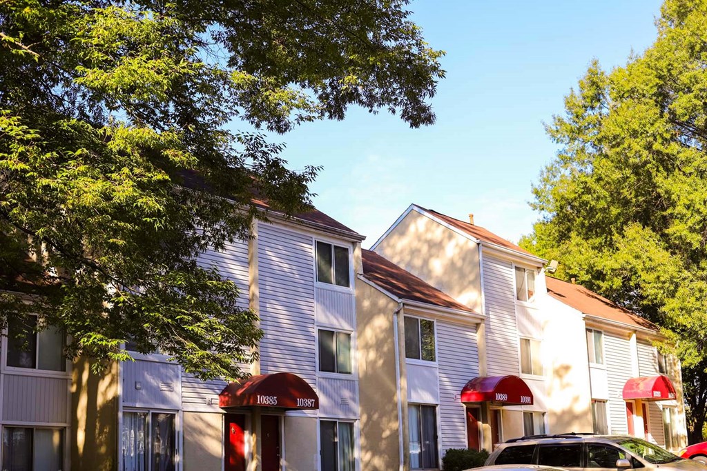 a row of houses with cars parked in front of them