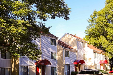 a row of houses with cars parked in front of them