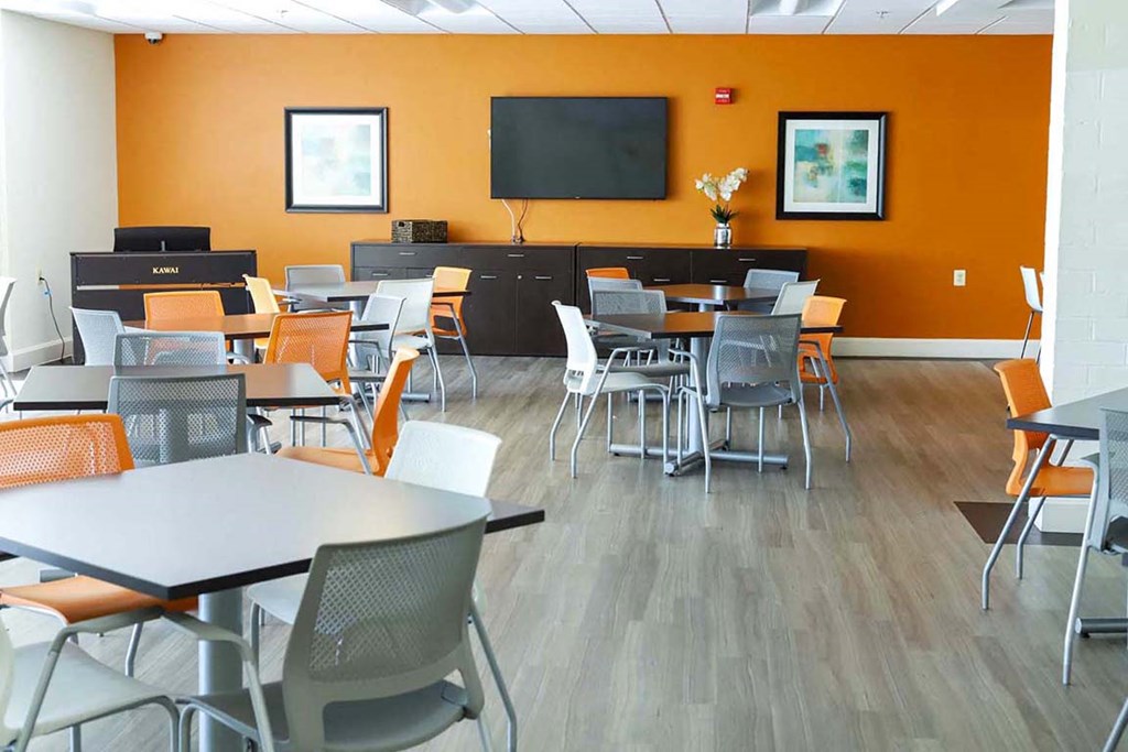 a dining room with tables and chairs and a tv