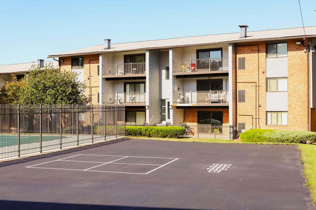 an empty parking lot in front of an apartment building