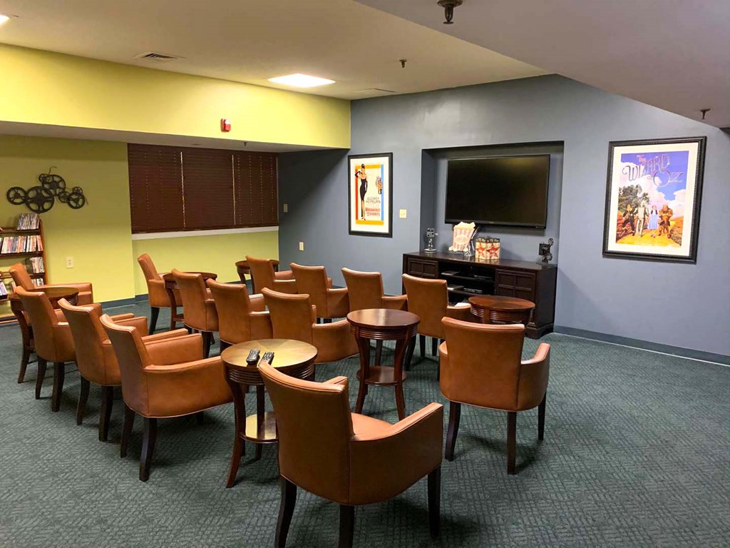 a waiting room with chairs and a television in a hospital