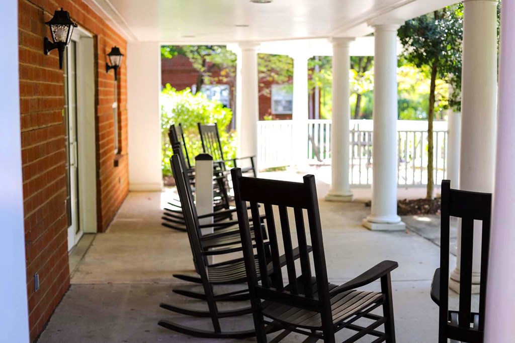 a row of rocking chairs on a porch