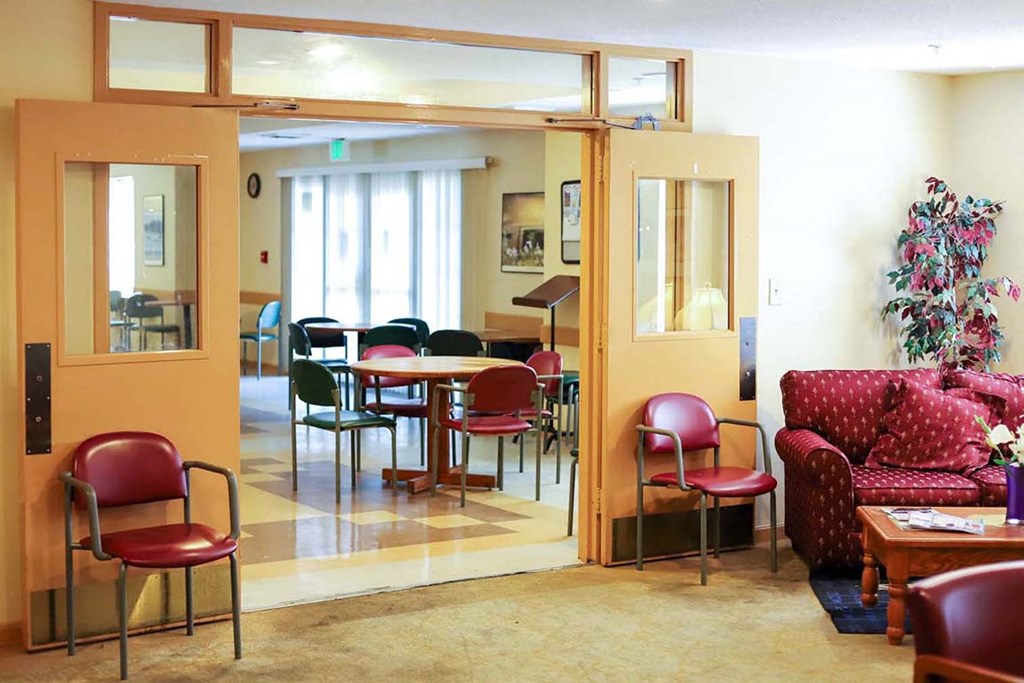 a lobby with chairs and tables and a piano