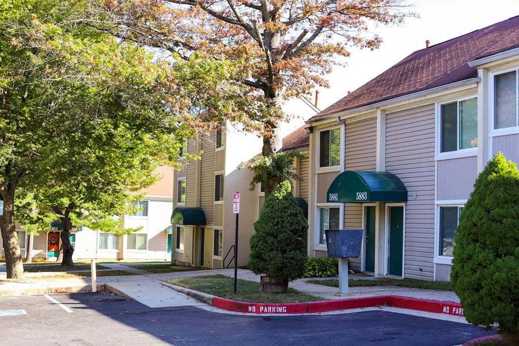 a street view of a row of houses with a red curb