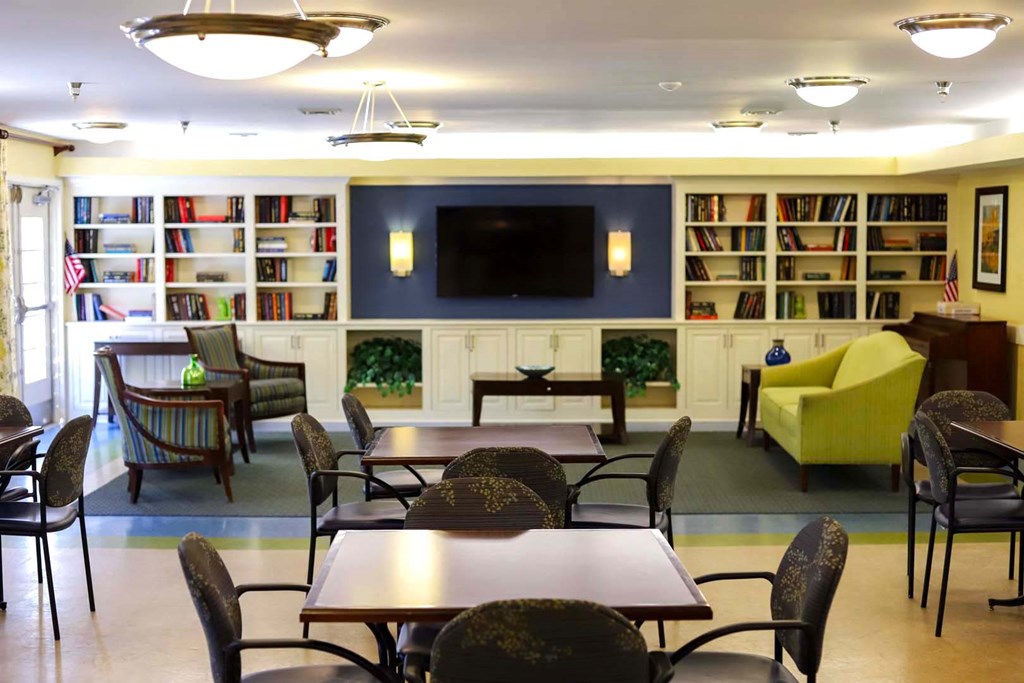 a living room with tables and chairs and a television