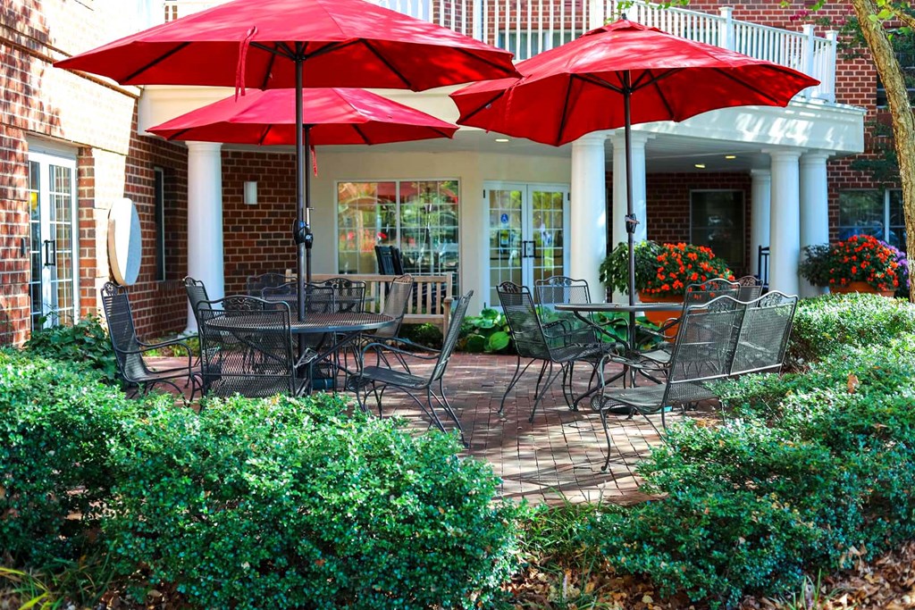 a patio with tables and chairs and umbrellas