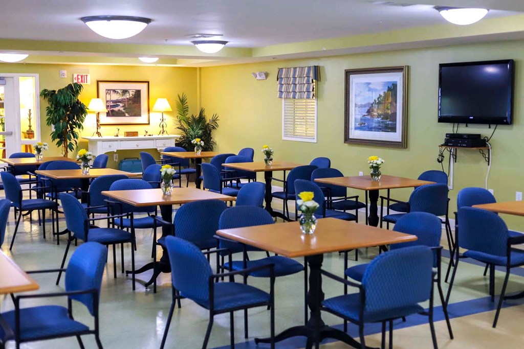 a dining room with tables and chairs and a tv