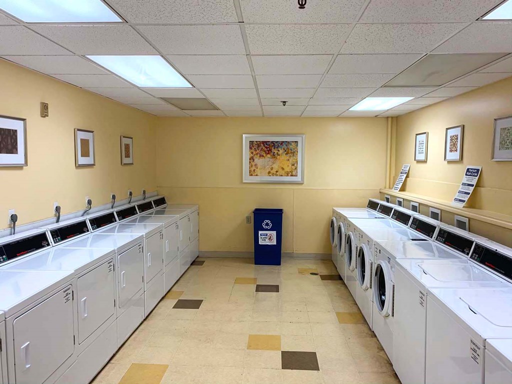 a large laundry room with several washers and dryers