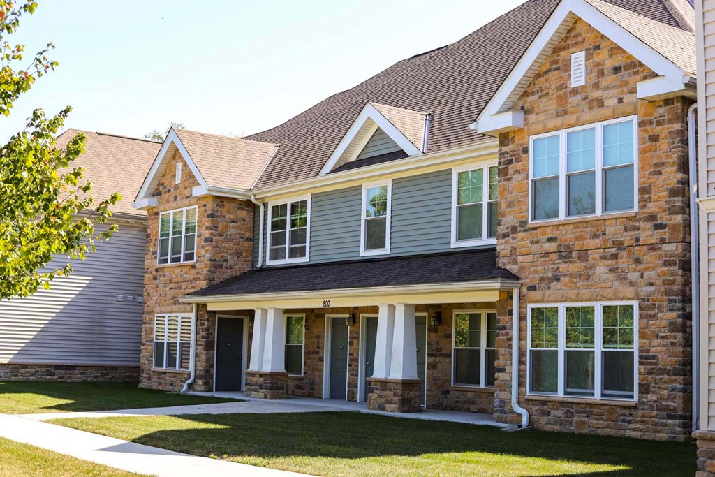 a large brick house with gray siding and white windows