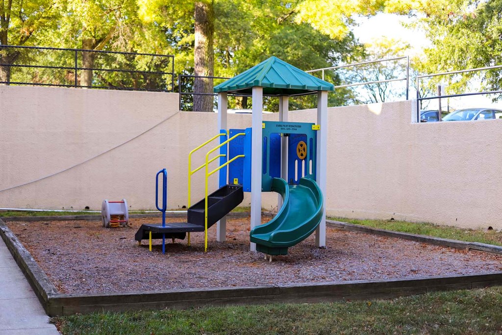 a playground with a swing set and slides in a park