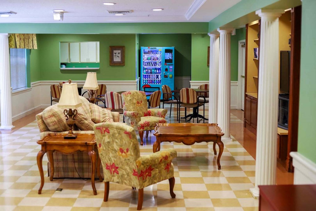 a living room with a checkered floor and a table and chairs