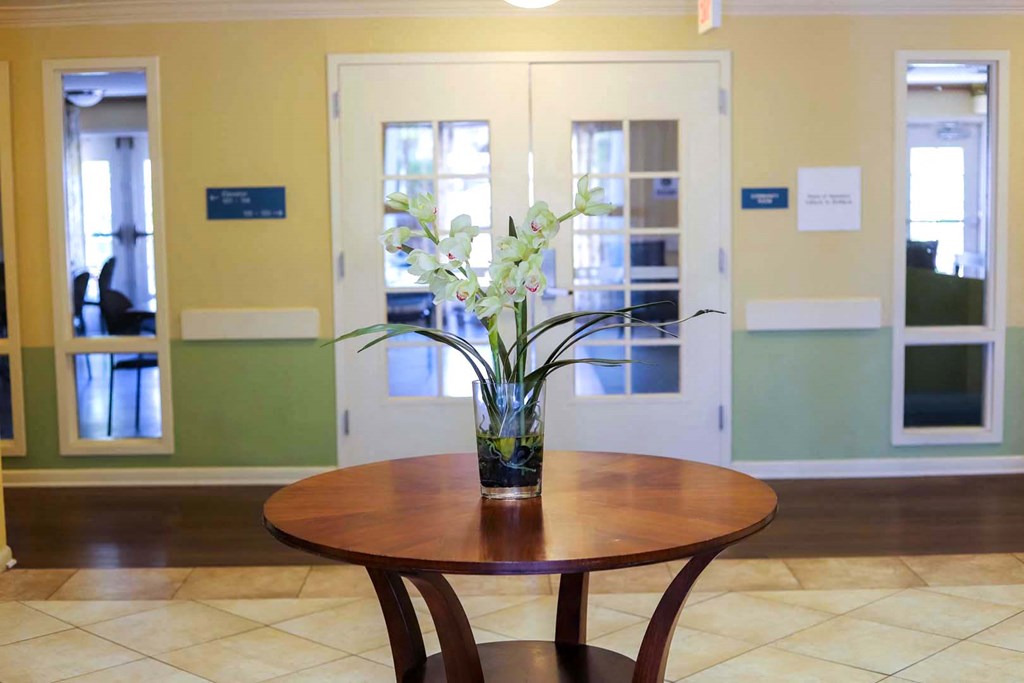 a vase of flowers on a table in a room with windows