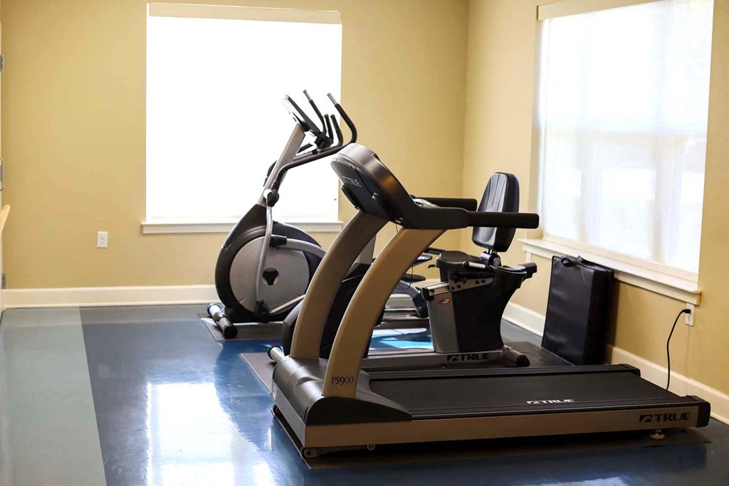 a treadmill and exercise equipment in a home gym