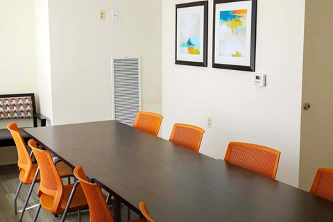 a conference room with a long table and orange chairs