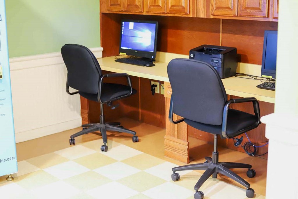 two chairs in front of a desk with a computer