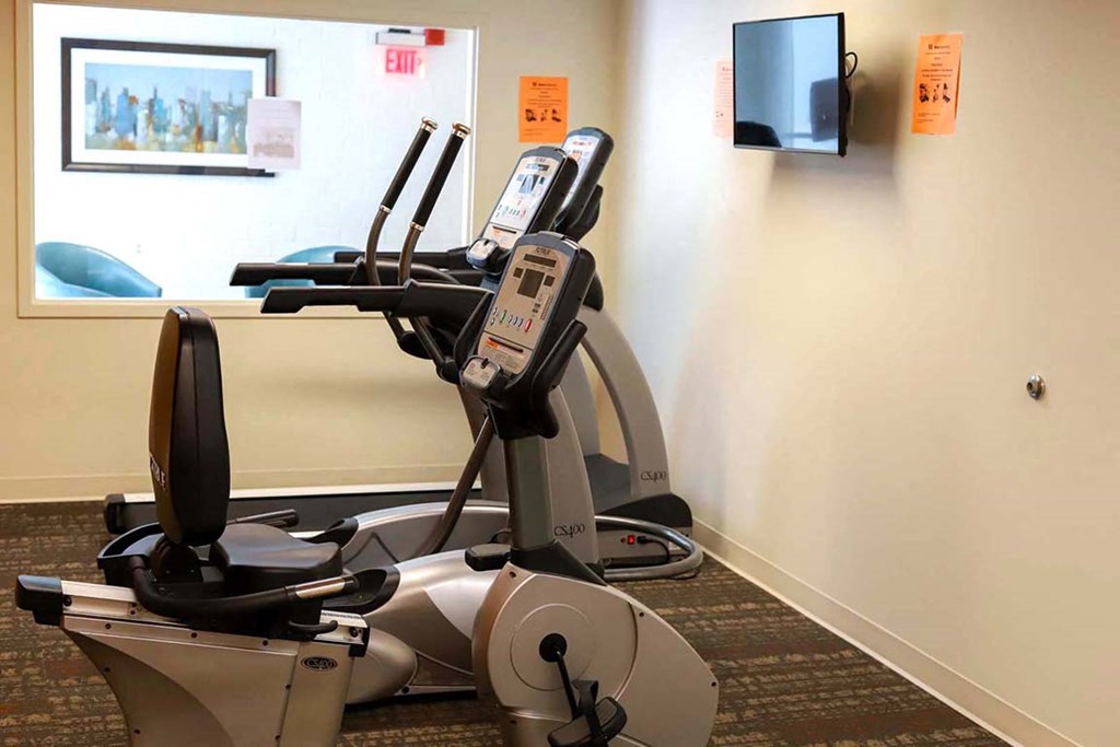 a gym with a exercise bike and a tv on the wall