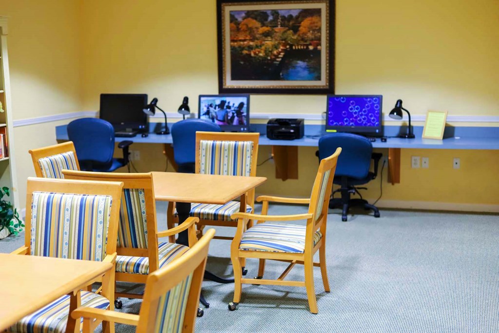 a conference room with tables and chairs and computers