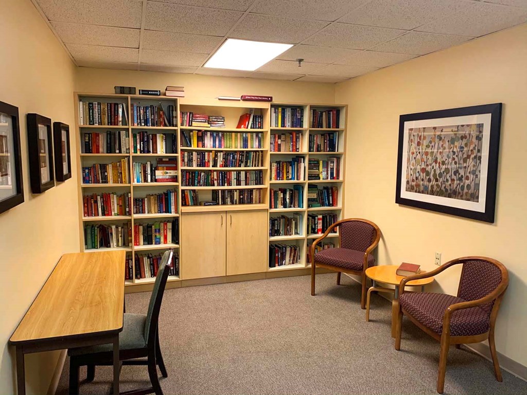 a library with a table and chairs and shelves of books
