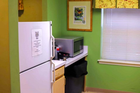 a kitchen with a refrigerator and a microwave on a counter
