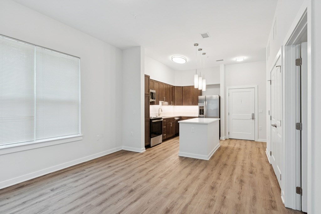 A kitchen with white appliances and wooden floors.