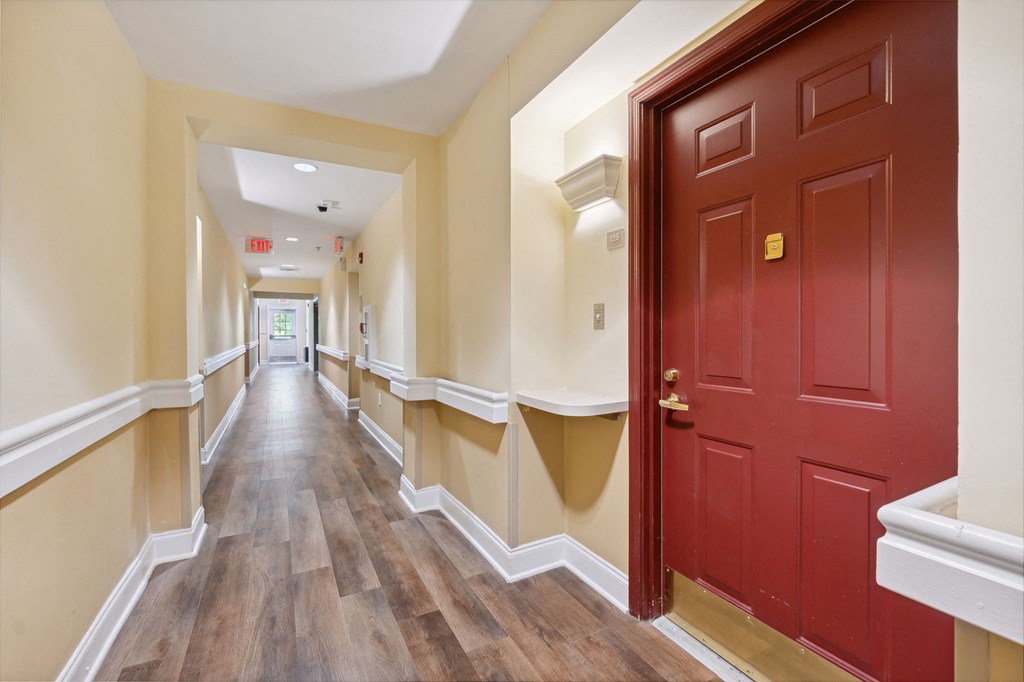 a long corridor with white walls and wooden floors