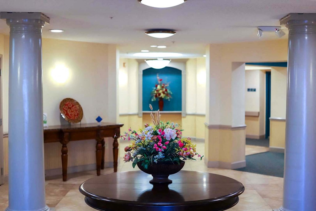 a lobby with a vase of flowers on a table