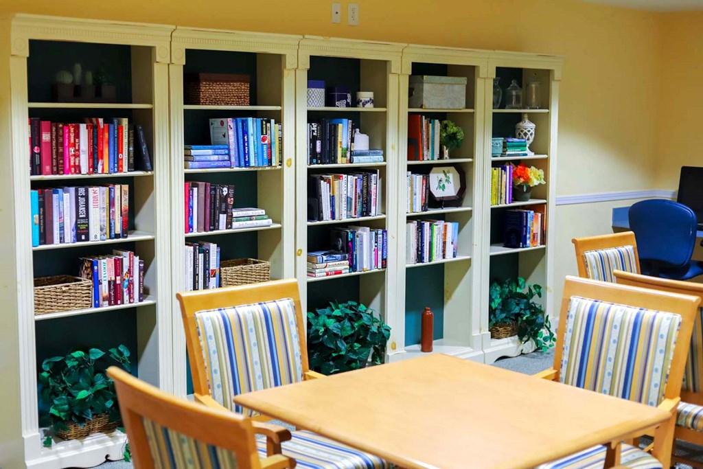 a library with a table and chairs and bookshelves