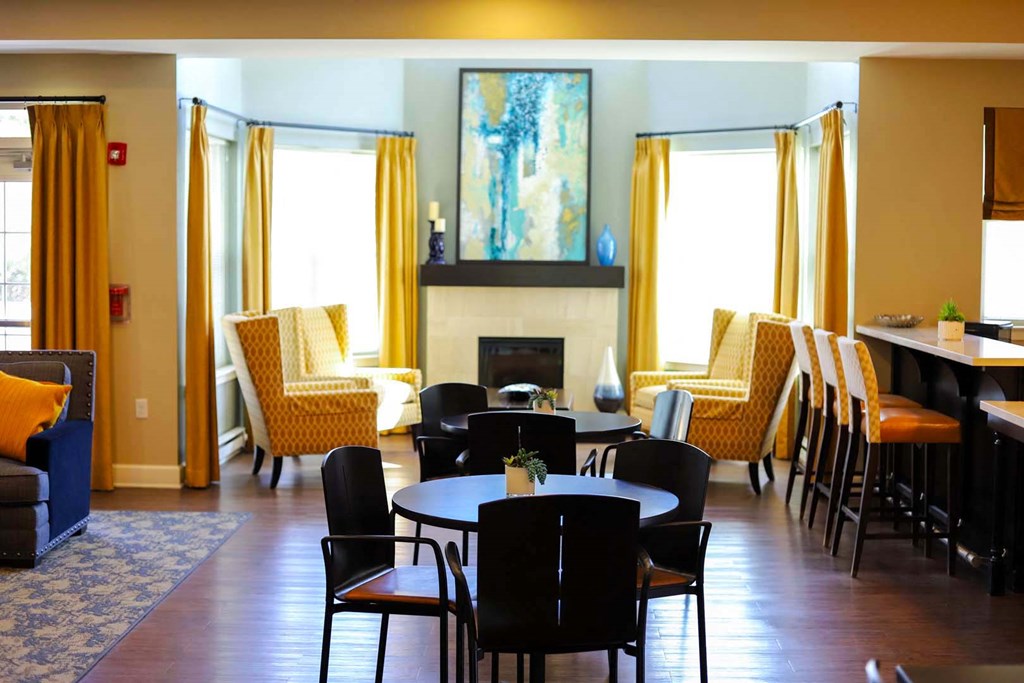 a living room with tables and chairs and a fireplace