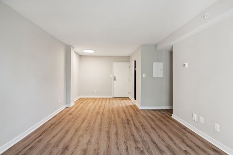 a living room with a hard wood floor and white walls