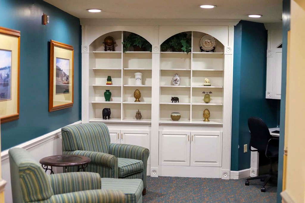a waiting room with two chairs and a shelf with vases