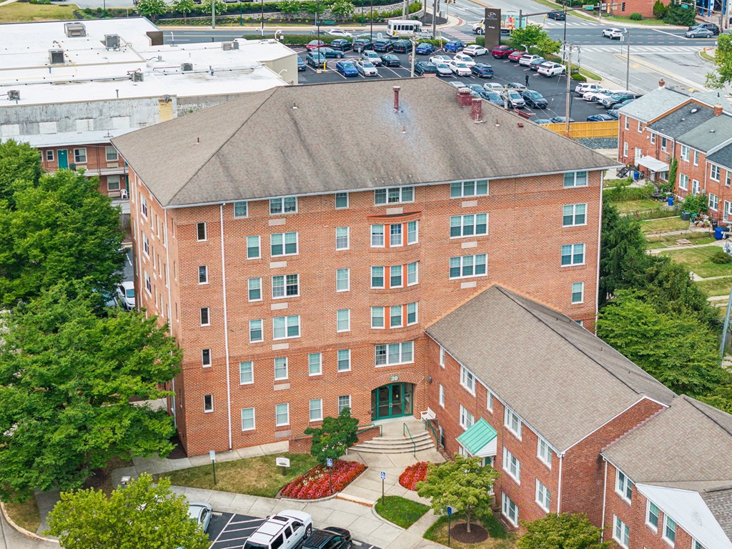 Brick 55+ apartment building at Park View at Towson with landscaped entrance and parking