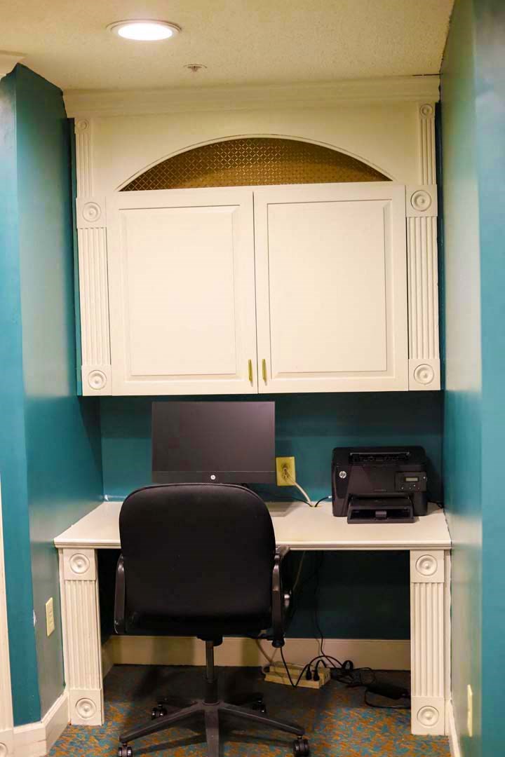 a desk with a computer and a chair in a room