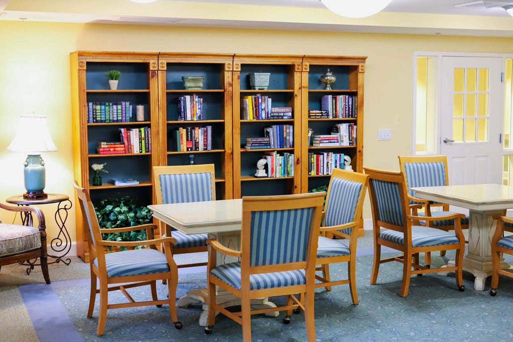 a library with tables and chairs and a book shelf
