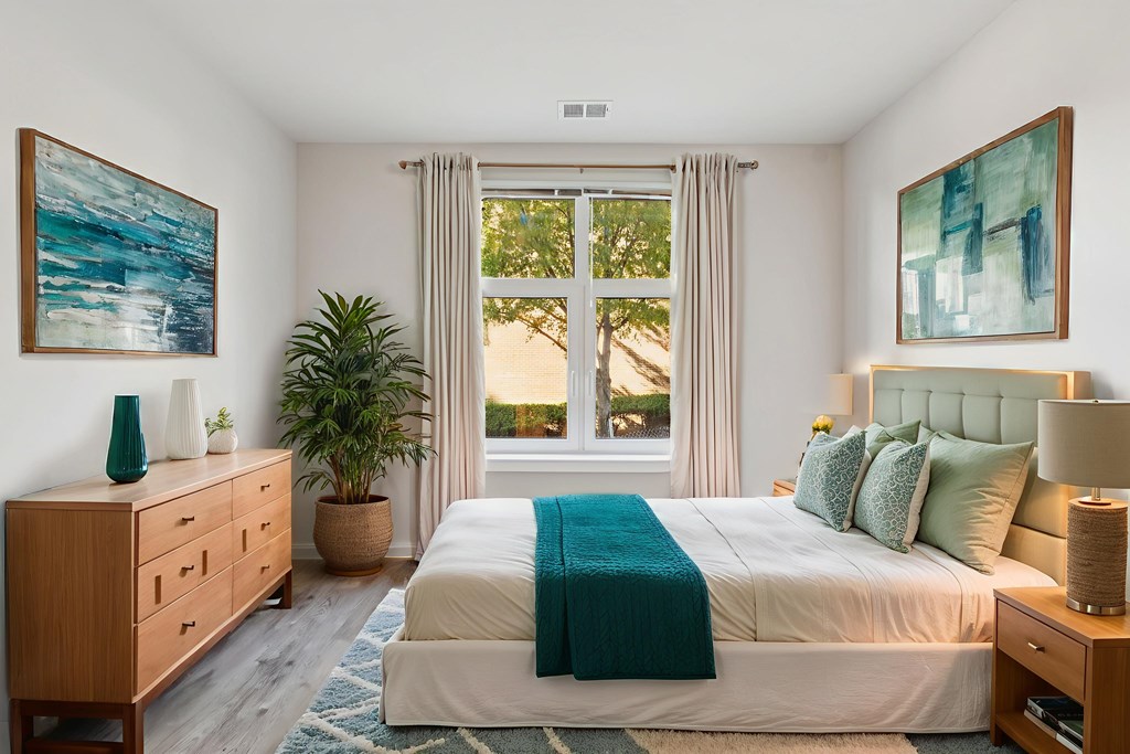 A bedroom with a large bed, a wooden dresser, and a painting on the wall.
