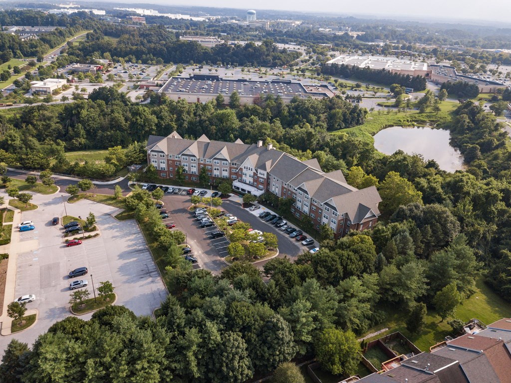 an aerial view of a building surrounded by trees and a parking lot