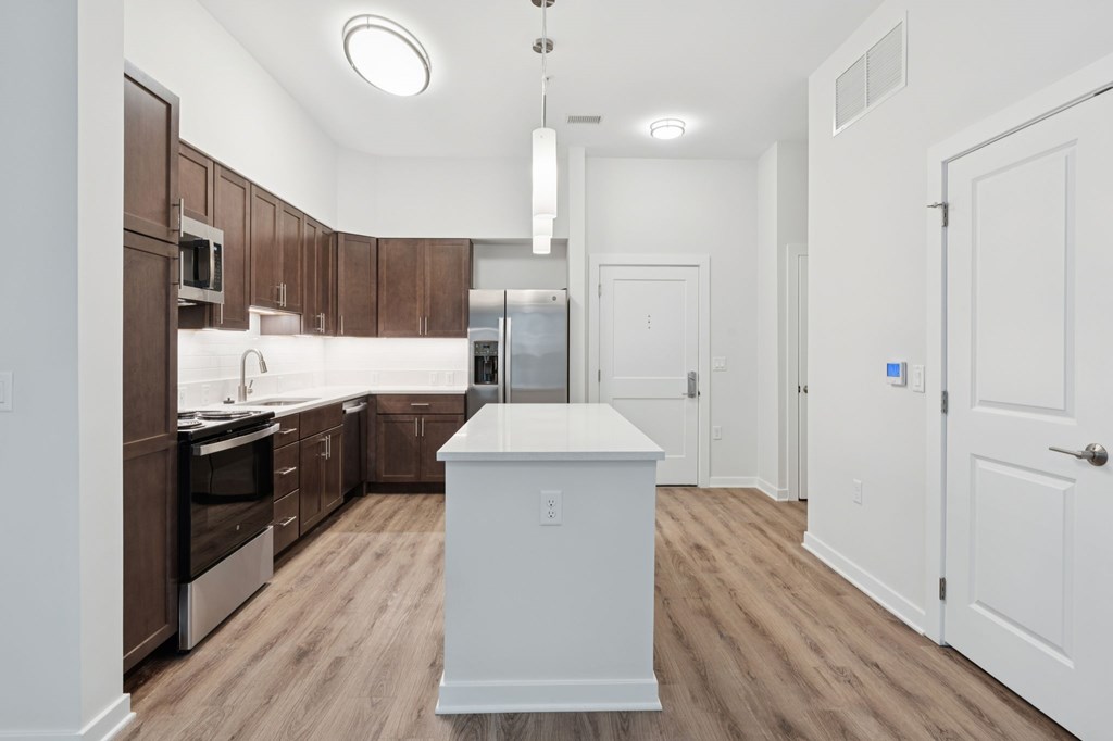 A kitchen with brown cabinets and a white island.