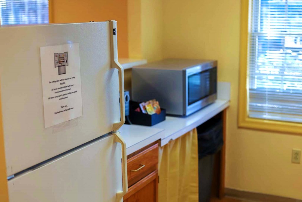 a kitchen with a refrigerator and a microwave on a counter