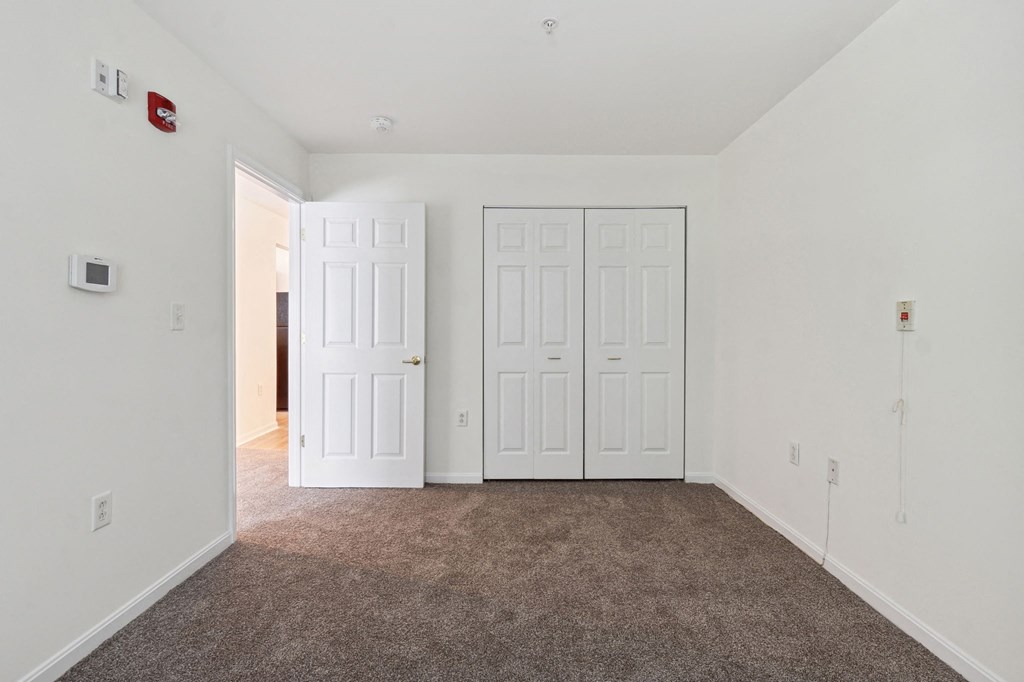 a bedroom with two doors and a carpeted floor