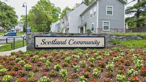A sign that says Scotland Community in front of some houses.