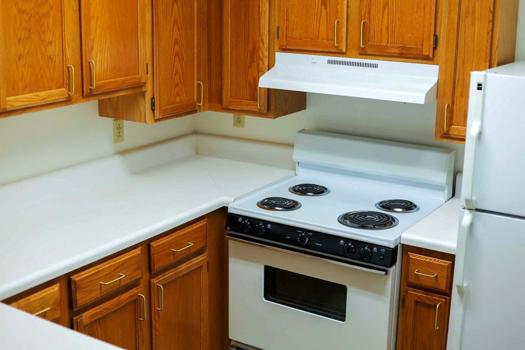 a kitchen with white appliances and wooden cabinets