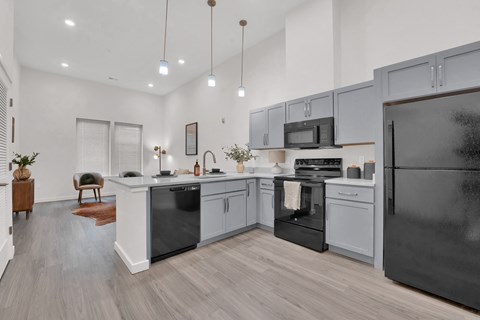 an open kitchen with stainless steel appliances and white cabinets