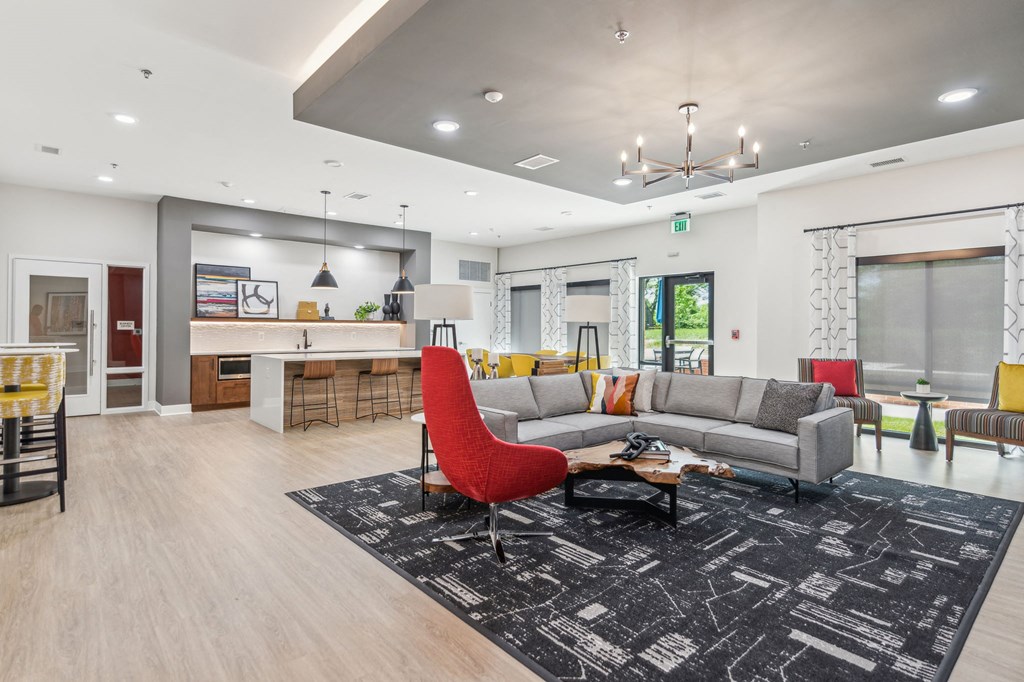 Legacy at Twin Rivers community room with a couch, tables, stools, plus shared kitchen space.