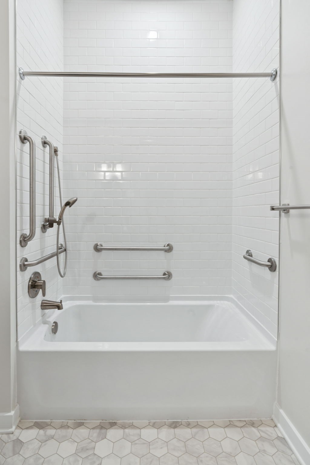 A white bathroom with a white tub and a white shower.