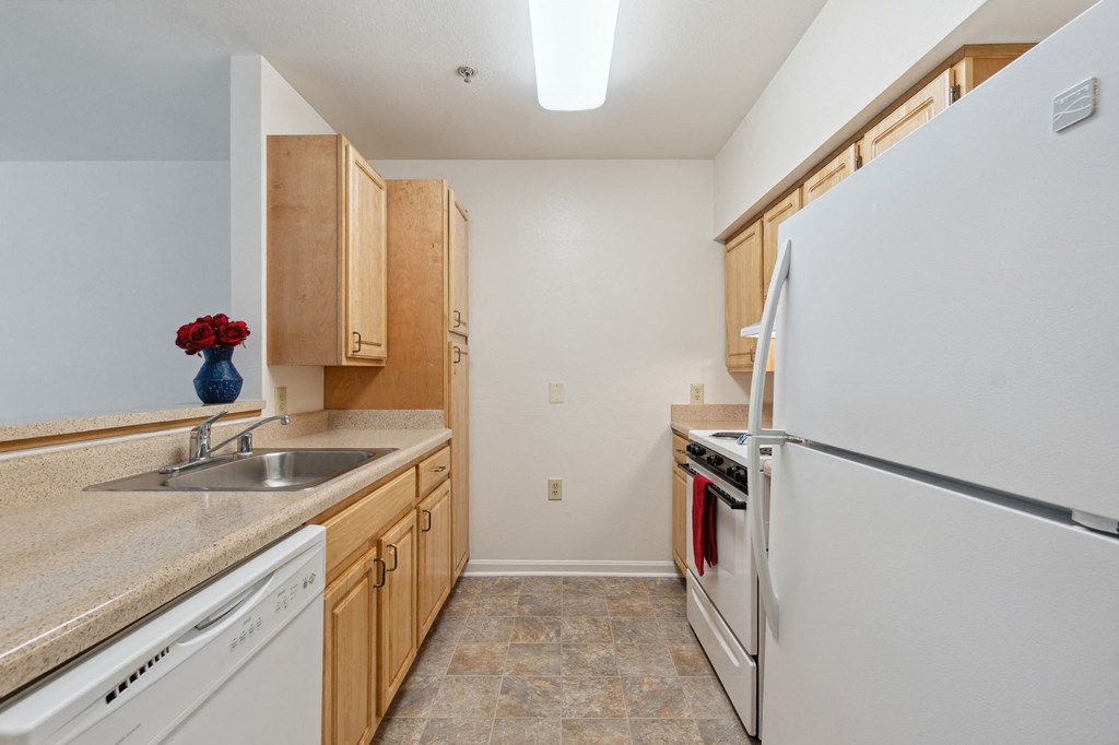 a kitchen with white appliances and wooden cabinets